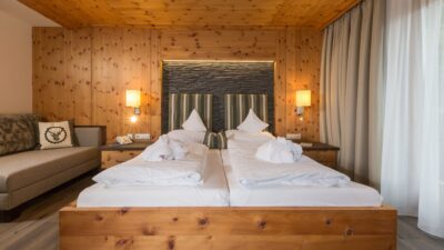 The rooms at the Hotel Naturglück Alpenhof are designed with lots of wood and love and have a balcony with a view of the hiking trails in Filzmoos.© Fotodesgin David