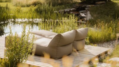 I grandi lettini accanto alla piscina naturale del Tauber's Bio Vitalhotel, il vostro hotel benessere in Alto Adige, vi invitano a sognare.© Tommy Halfter
