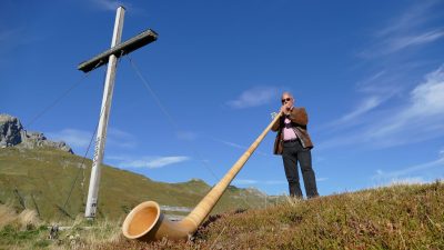 Seniorchef Oskar Jäger mit AlphornWanderhotel Jägeralpe: Wanderung an einem Kirchlein vorbei auf den Simmel mit dem Weltfriedenskreuz, dort spielt der Seniorchef Alphorn Seniorchef Oskar Jäger mit AlphornWanderhotel Jägeralpe: Wanderung an einem Kirchlein vorbei auf den Simmel mit dem Weltfriedenskreuz, dort spielt der Seniorchef Alphorn
