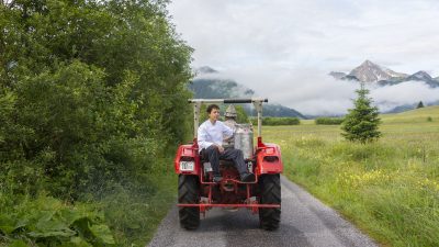 Oesterreich Austria Tirol Tannheimer Tal Graen Wanderhotel HOTEL LUMBERGER HOF Milch holen mit Traktor Guedner Traktor Oesterreich Austria Tirol Tannheimer Tal Graen Wanderhotel HOTEL LUMBERGER HOF Milch holen mit Traktor Guedner Traktor