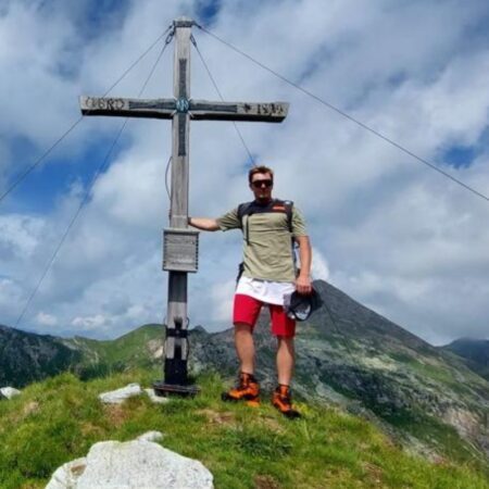Wanderer steht am Berggipfel Wanderer steht am Berggipfel