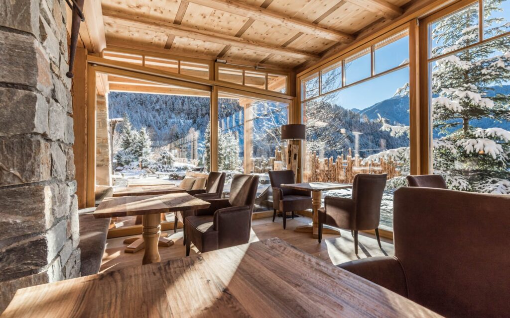 Der große Speisesaal im Naturhotel Lüsnerhof gewäht einen tollen Blick auf die Südtiroler Dolomiten bei deinem Winterurlaub in Lüsen.