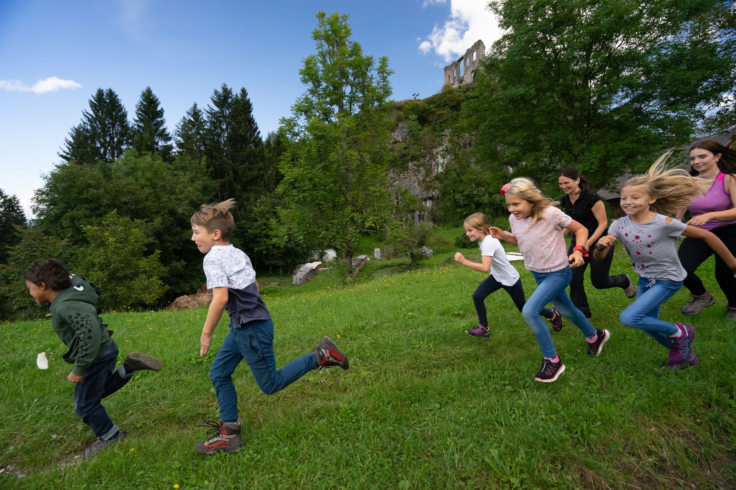 Kinder laufen über eine Wiese