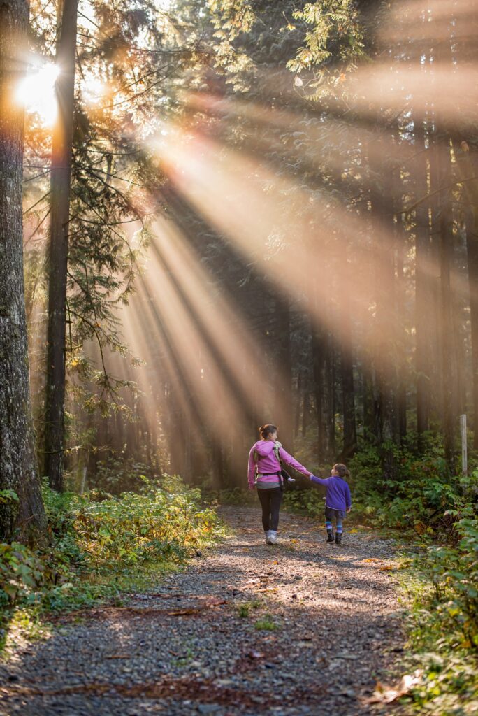 Mutter Kind im Wald beim Spazieren