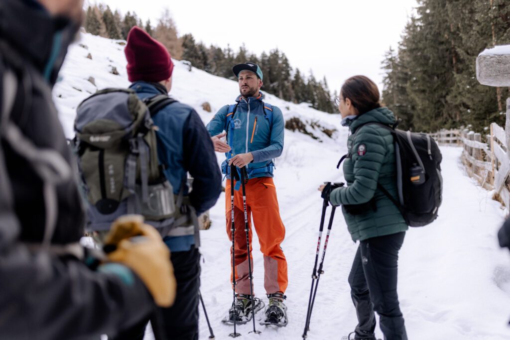 Wanderconcierge erklärt Winterwanderern den Weg