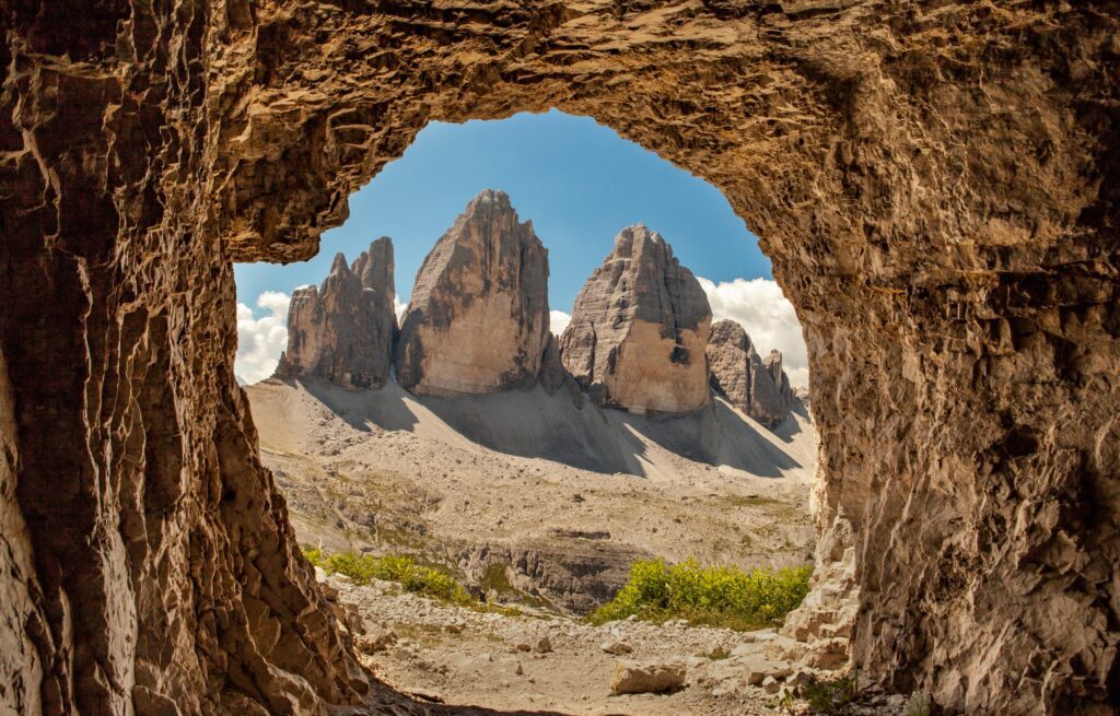 Die Drei Zinnen in den Südtiroler Dolomiten fotografiert durch ein Felsloch