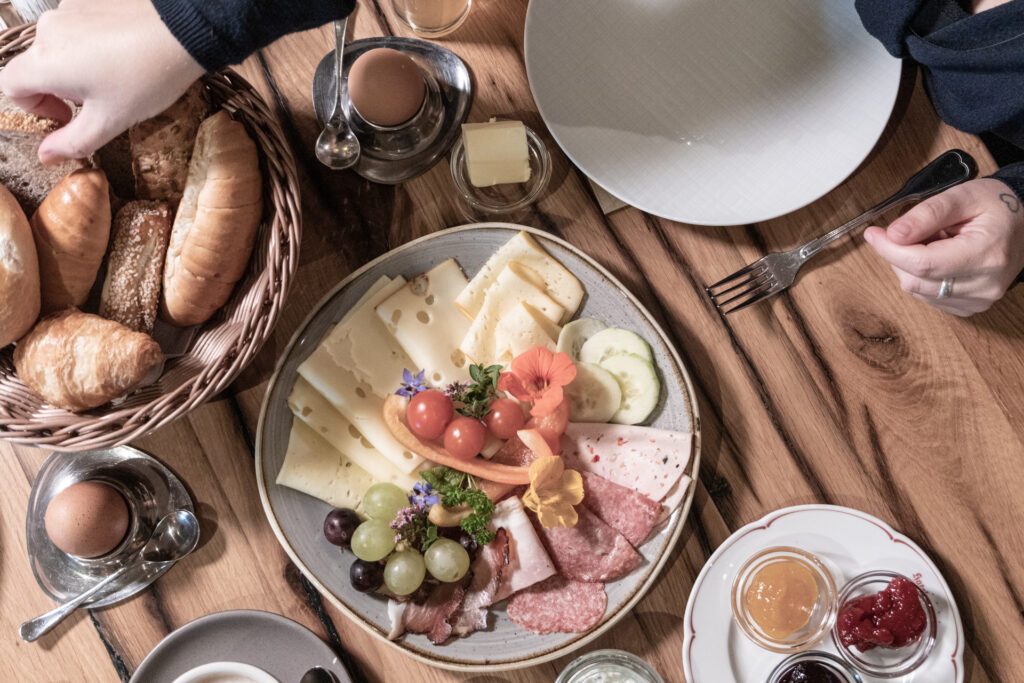 Ein Teller mit Wurst, Käse, Weintrauben und Tomaten von oben fotografiert