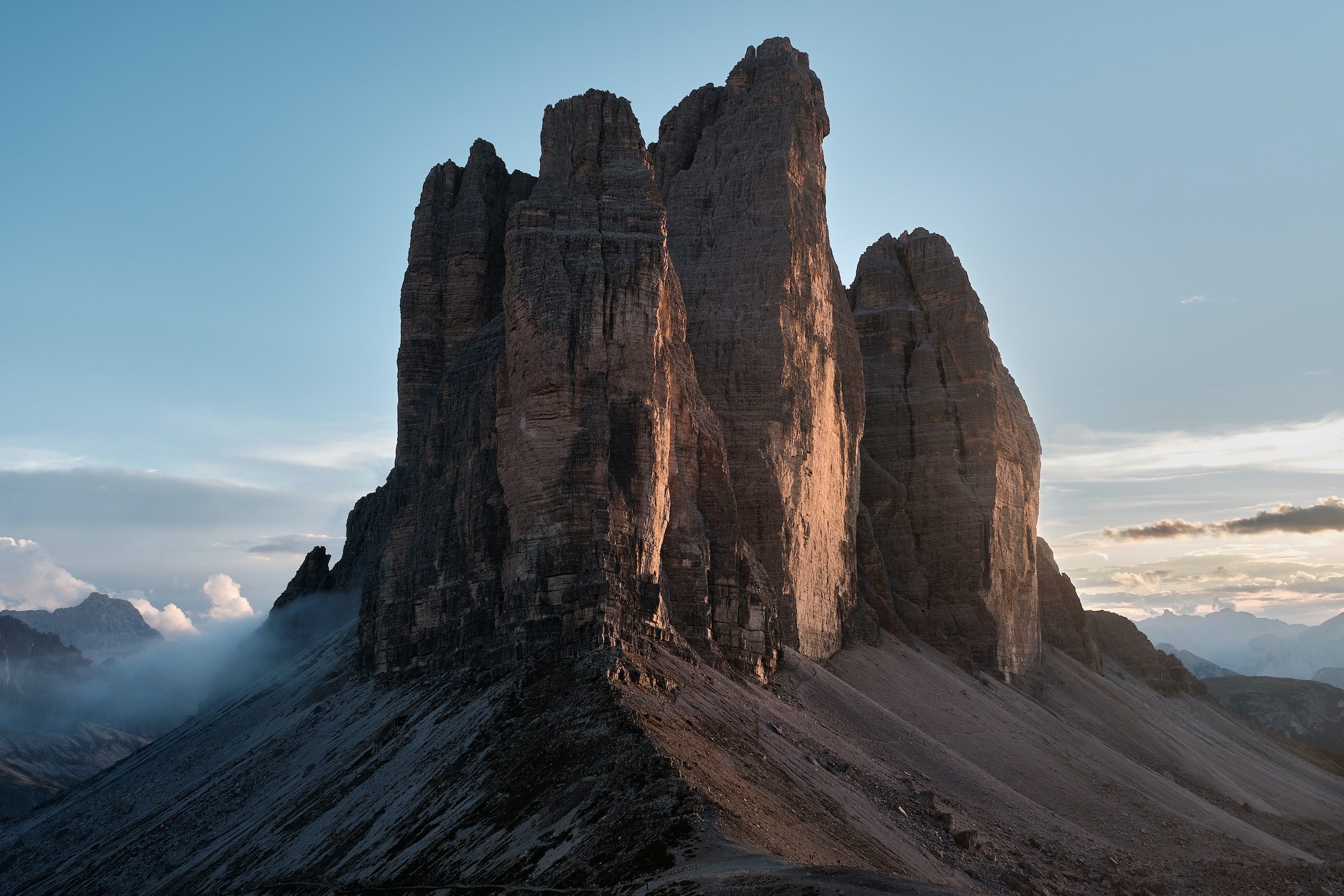 Exponiert stehen die drei Zinnen in Südtirol als riesiges Felsmassiv im Abendrot