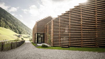 Jaufentalerhof außen Fassade aus Holz von der Seite fotografiert die Sonne scheint darüber(C) Hannes Niederkofle