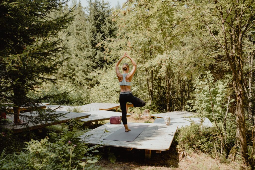 Frau die Yoga praktiziert im Wald.