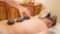 Hotstone Massage im Böglerhof - Frau bekommt eine Massage drei Steine liegen auf ihrem Rücken