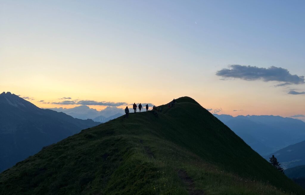 Wanderer auf dem Weg zur Stollespitze in Südtirol bei Sonnenaufgang