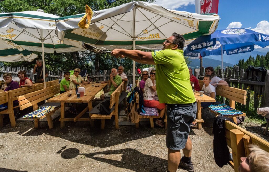 Manni, Gastgeber im Südtiroler Erlebnisort Gassenhof wendet Kaiserschmarrn in der Luft