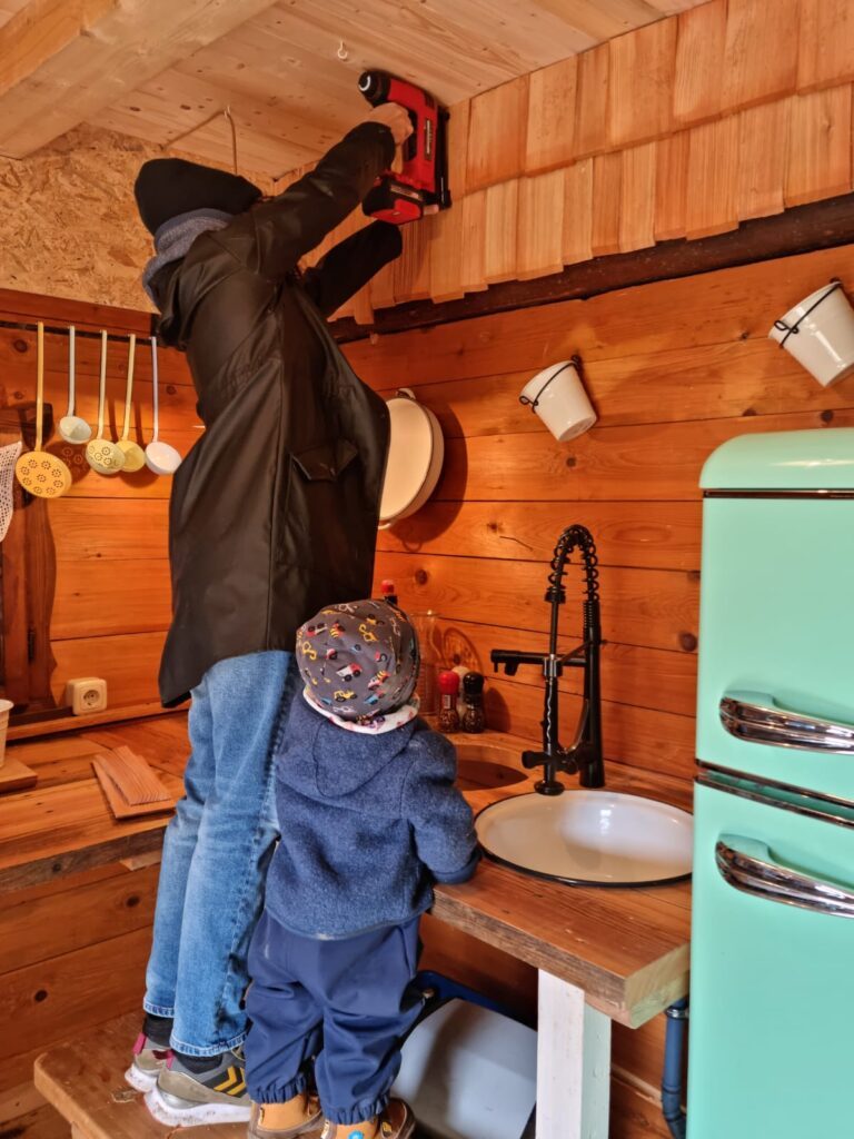 Vater und Sohn bringen in der Almhütte vom Wanderhotel Glemmtalerhof im Salzburger Land Schindeln an