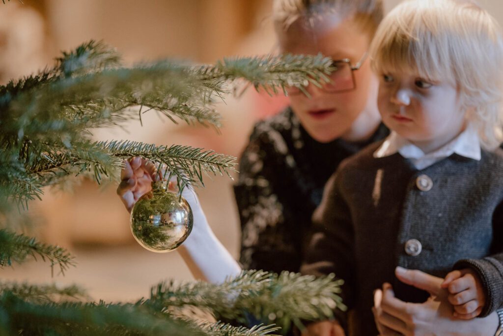 Kind schmückt den Weihnachtsbaum im Wanderhotel Vierbrunnenhof im Südtiroler Antholzertal