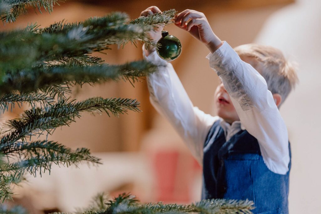 Kind schmückt den Weihnachtsbaum im Wanderhotel Vierbrunnenhof im Südtiroler Antholzertal