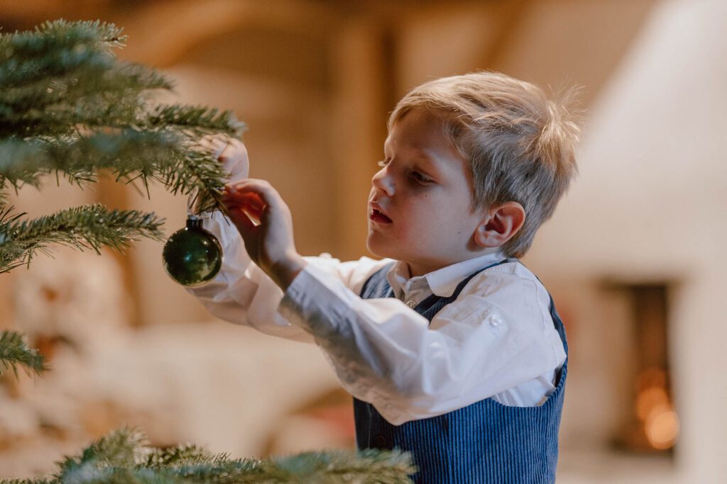 Kind schmückt den Weihnachtsbaum im Wanderhotel Vierbrunnenhof im Südtiroler Antholzertal