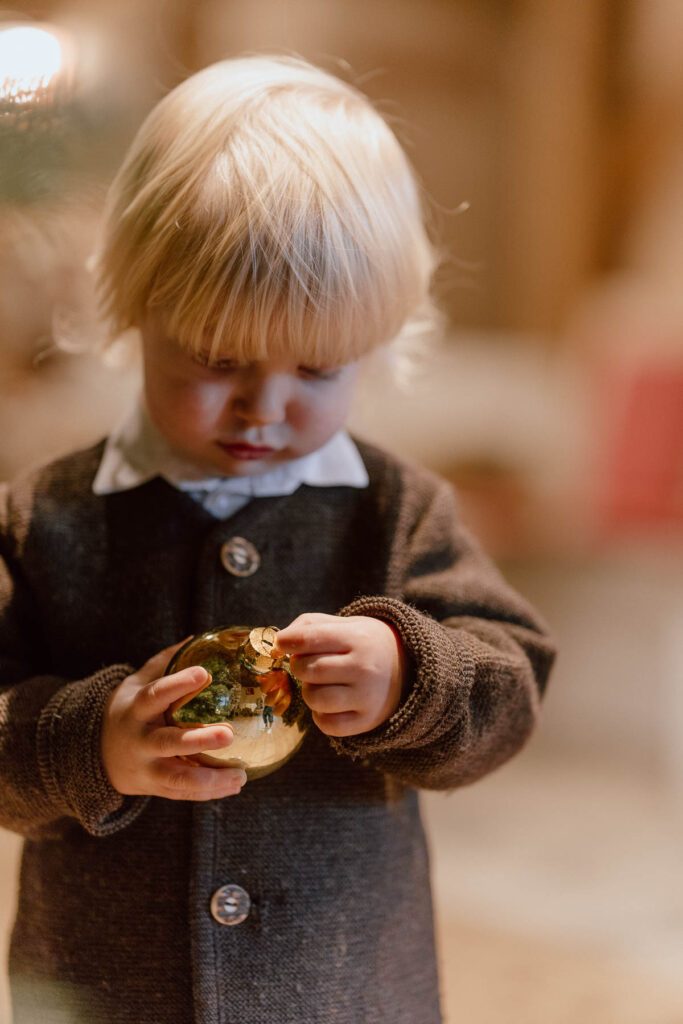 Kind schmückt den Weihnachtsbaum im Wanderhotel Vierbrunnenhof im Südtiroler Antholzertal