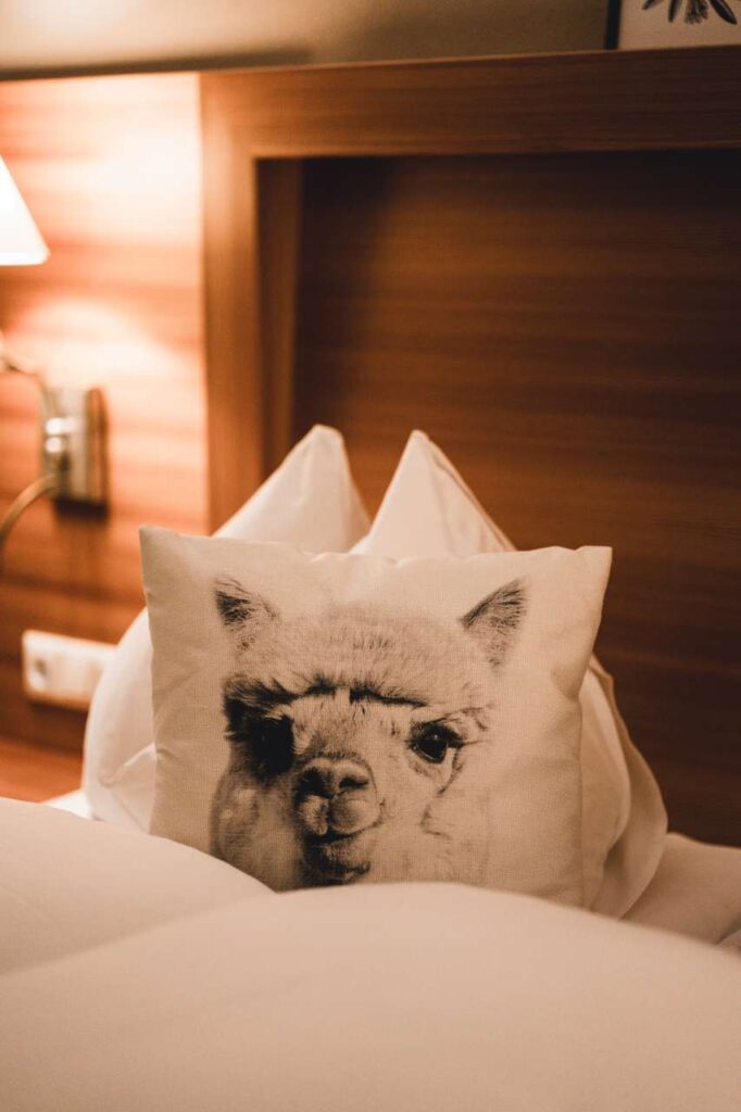 Doppelbett mit Alpaka Accessoires des Alpakazimmers im Wanderhotel Alte Post, Großarl