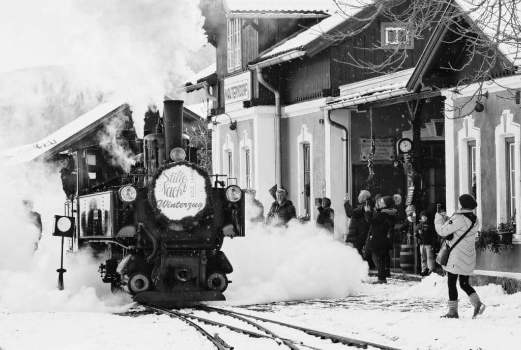 Die historische Dampflokomotive Taurachbahn steht in einem winterlichen Bahnhof