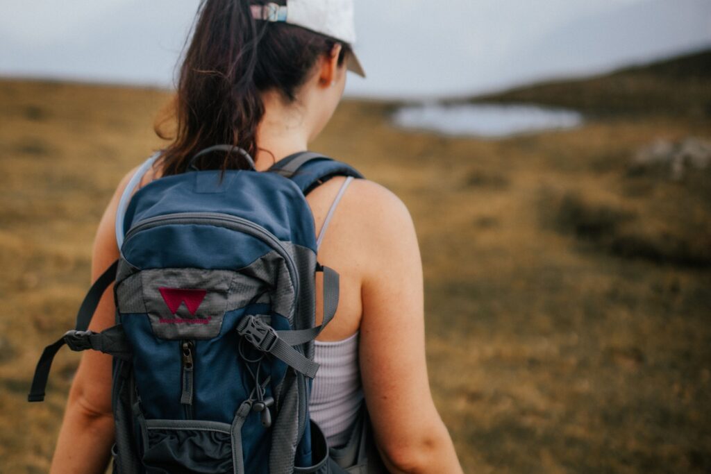 Eine Wanderin mit Wanderhotels-Rucksack in den Österreichischen Alpen.