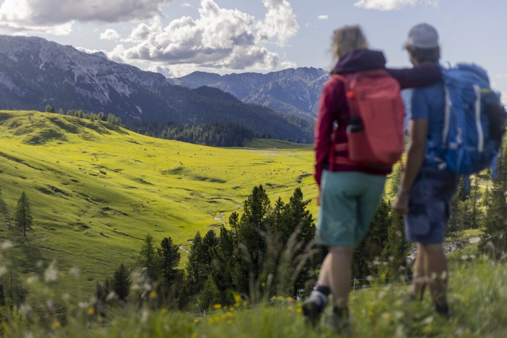 Zwei Wanderer blicken in die Ferne und genießen den Moment.