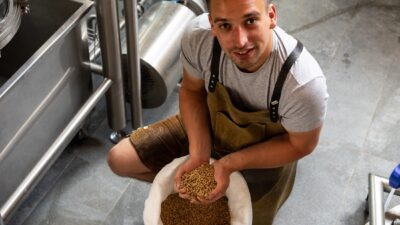 Mann hält Getreidekörner in der Hand am Katschberg in der Brauerei von Katsch Beer(c) Carolin Thiersch