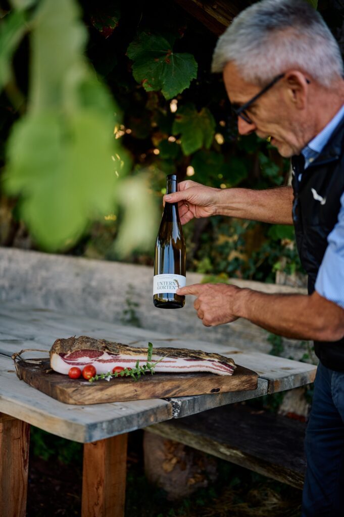 Gastgeber Stefan Fauster mit Speck und Wein aus Südtirol Wanderhotel Drumlerhof